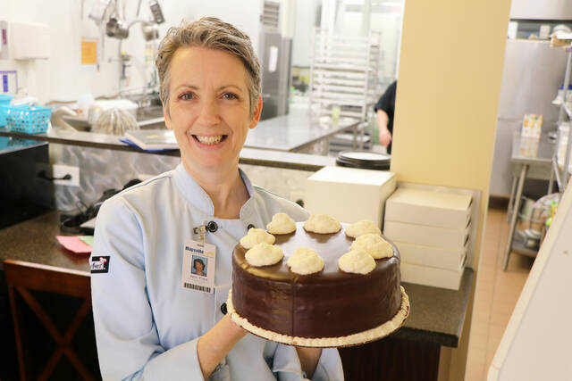 The College Cafe’ is set to open Friday with the College Bakery opening Thursday. Chef Ann Flora displays a cake from the bakery.
