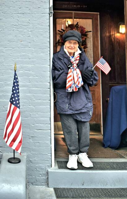 Alice Gallenstein watches the recent Veterans Day parade from her doorstep in downtown Maysville.